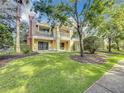 Two-story townhome with a balcony, surrounded by lush landscaping and mature trees at 7510 Seven Eagles Way # 7510, Reunion, FL 34747
