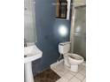 Bathroom with white toilet and pedestal sink at 1604 Royal Palm Dr, Edgewater, FL 32132