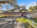 Brick ranch house exterior with red front door and attached garage at 5100 Helen Ct, St Cloud, FL 34772