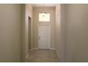 A light-colored hallway with tile floors and a white door at 1569 Thetford Cir, Orlando, FL 32824