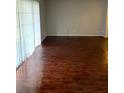 Bright living room with dark wood laminate flooring and sliding glass doors at 4119 Dijon Dr # 4119H, Orlando, FL 32808