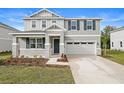 Two-story house with gray siding, stone accents, and a two-car garage at 670 Summit River Dr, Apopka, FL 32712