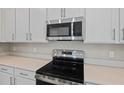 Stainless steel range and microwave installed above in a modern kitchen at 670 Summit River Dr, Apopka, FL 32712