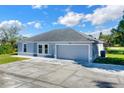 Newly built home with gray exterior, two-car garage, and well-maintained lawn at 905 Gascony Ct, Kissimmee, FL 34759