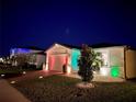 Night view of a one-story home with colorful lights and landscaping at 161 Andreas St, Winter Haven, FL 33881