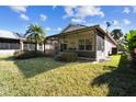 Home with screened patio, grassy yard, and lush landscaping at 200 Grand Canal Dr, Kissimmee, FL 34759