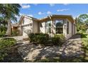Tan house with paved walkway, landscaping, and large windows at 200 Grand Canal Dr, Kissimmee, FL 34759