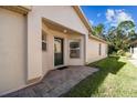 House entrance with dark green door, brick walkway, and side yard at 200 Grand Canal Dr, Kissimmee, FL 34759