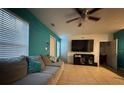 Living room with gray sectional sofa, a large TV, and teal walls at 210 Majors Ln # A, Kissimmee, FL 34743