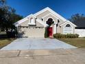 Two-story house with a red door and attached garage at 2213 Rio Pinar Lakes Blvd, Orlando, FL 32822