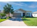 Single-story house with stone accents and a two-car garage at 249 Treviso Dr, Kissimmee, FL 34759