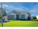 Single story house with gray garage door and lush landscaping at 249 Treviso Dr, Kissimmee, FL 34759