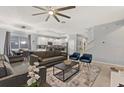 Spacious living room with gray couches, a coffee table, and a large TV at 4449 Shiva Loop, Kissimmee, FL 34746
