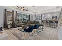 Open-concept living room and kitchen with gray sectional sofa, dining table and bar seating at 4449 Shiva Loop, Kissimmee, FL 34746