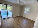 Bright bedroom with new flooring and sliding glass doors leading to the pool at 1117 Ingram St, Kissimmee, FL 34744