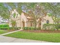 Spanish style home with well manicured lawn and mature trees at 1233 Aquila Loop, Celebration, FL 34747