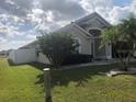 Side view showcasing the house's architectural style and landscaping at 2303 Walnut Canyon Dr, Kissimmee, FL 34758