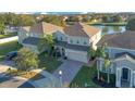 Three houses near a lake with garages and paved driveways at 2811 Sonata Ct, St Cloud, FL 34772