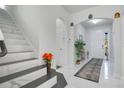 Bright entryway with marble-look flooring and modern staircase at 2811 Sonata Ct, St Cloud, FL 34772