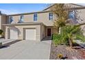 Tan two-story townhome with two-car garage and landscaping at 355 Highcrest Rd, Davenport, FL 33896