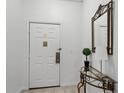 Condo entryway with white door, glass-top table, and mirror at 9051 Treasure Trove Ln # 207, Kissimmee, FL 34747