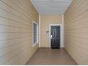 Private condo entryway with a black door and a small window at 9051 Treasure Trove Ln # 207, Kissimmee, FL 34747