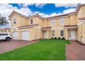 Front view of two story townhouse, two car garage, and landscaped lawn at 1355 Pacific Rd, Kissimmee, FL 34759