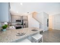 Open concept kitchen with granite island and gray cabinets at 1355 Pacific Rd, Kissimmee, FL 34759