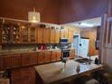 Well-equipped kitchen with wood cabinets and granite countertops at 2606 Royal Fern Pl, Kissimmee, FL 34758