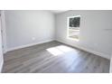 Bright bedroom with grey wood-look flooring and large window at 297 Oak Lane Way, Ocala, FL 34472