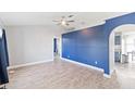 Spacious living room with blue accent wall and wood-look tile floors at 557 Dove Ct, Kissimmee, FL 34759