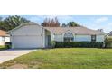 House exterior featuring a single-story home with attached garage and well-maintained lawn at 607 Tamarin Ln, Kissimmee, FL 34759