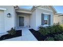 Front entry with gray door, walkway, and landscaping at 741 Watusi Way, Saint Cloud, FL 34772