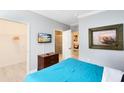 Bedroom with teal bedding, large TV, and adjacent bathroom at 1301 Tuscan Ter # 9107, Davenport, FL 33896