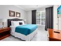 Spacious bedroom with teal bedding and large window at 1301 Tuscan Ter # 9107, Davenport, FL 33896