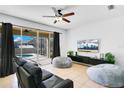 Living room with sliding doors leading to a pool and patio, featuring two beanbag chairs and a leather sofa at 3571 Maple Ridge Loop, Kissimmee, FL 34741