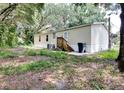 Back of the mobile home with wooden deck and AC unit at 4914 Dove Ln, Auburndale, FL 33823