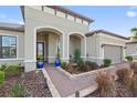 Front entrance with brick walkway, landscaping, and arched entryway at 972 Ladera Ranch Rd, Kissimmee, FL 34759