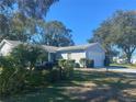 Exterior view of a light blue vinyl-sided house with a two-car garage and well-maintained lawn at 5062 El Destino Dr, Leesburg, FL 34748