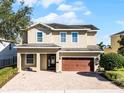 Two-story house with brown garage door and a brick paved driveway at 7639 Wilmington Loop, Kissimmee, FL 34747