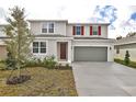 Two-story house with gray siding, red shutters, and a two-car garage at 1736 Carnelian St, Deland, FL 32720