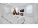 Bright living room with white furniture, decorated for the holidays at 2644 Summer Clouds Way, Kissimmee, FL 34744