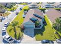 Aerial view showcases a teal house with a two-car garage and a well-maintained yard at 307 Fox Loop, Davenport, FL 33837