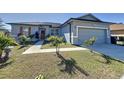 Newly built one-story home with gray siding, landscaping, and a two-car garage at 320 Anchovie Ct, Kissimmee, FL 34759