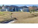 Newly built one story home with gray siding, landscaping, and a two car garage at 320 Anchovie Ct, Kissimmee, FL 34759
