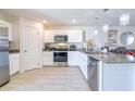 Modern kitchen with stainless steel appliances and granite countertops at 680 Hillview Loop, Haines City, FL 33844