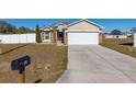 House with a red door, white garage door, and mailbox at 825 Desmoines Pl, Kissimmee, FL 34759