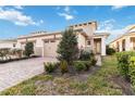 Two-story home with tan exterior, two-car garage, and landscaped yard at 2482 Yellow Brick Rd, St Cloud, FL 34772