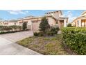 Two-story home with tan exterior, two-car garage, and landscaped yard at 2482 Yellow Brick Rd, St Cloud, FL 34772