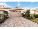 Two-car garage with brick paver driveway and landscaping at 2482 Yellow Brick Rd, St Cloud, FL 34772